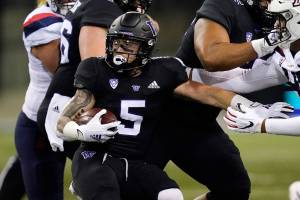 Washington's Sean McGrew carries during the first half of the team's NCAA college football game against Arizona on Saturday, Nov. 21, 2020, in Seattle. (AP Photo/Elaine Thompson)