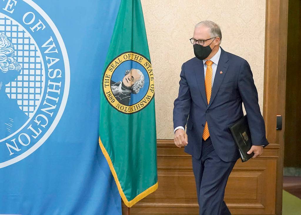 Washington Gov. Jay Inslee arrives to talk to reporters joining him remotely at the Capitol in Olympia on Nov. 4, a day after he was re-elected to a third term as governor. (AP Photo/Ted S. Warren, File)