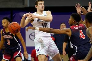 Arizona's Dalen Terry (4) knocks the ball away from Washington's Erik Stevenson (10) during the first half of an NCAA college basketball game Thursday, Dec. 31, 2020, in Seattle. (AP Photo/Elaine Thompson)