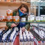 Cece Stafford arranges stock Wednesday afternoon at Alchemy Health in Alderwood Mall on December 16, 2020. (Kevin Clark / The Herald)