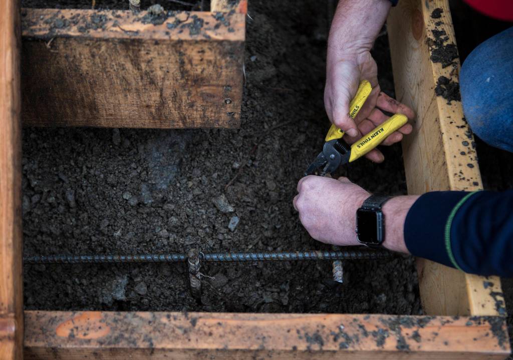 Work on new concrete steps at a home in Lynnwood. (Olivia Vanni / The Herald)