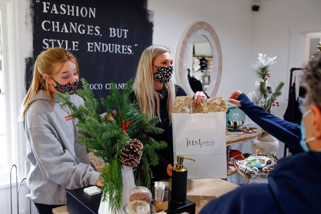 Claire Vondemkempt (left) and Jami Sollid check out customers at Just James Boutique in Stanwood on Nov. 28. (Kevin Clark / The Herald)
