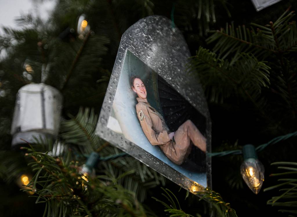 A photograph of a soldier sitting in a large airplane engine hangs on the tree on Crosbys property in Lynnwood. (Olivia Vanni / The Herald)