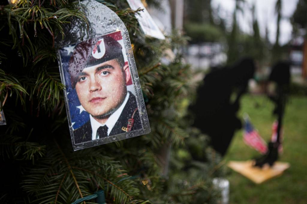 A photograph of a soldier hangs on the tree outside of Crosbys home in Lynnwood. (Olivia Vanni / The Herald)