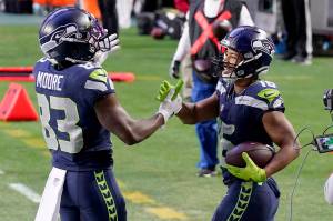Seattle Seahawks wide receiver Tyler Lockett (16) celebrates with David Moore (83) following Locketts fourth-quarter touchdown against the San Francisco 49ers Sunday in Glendale, Ariz. (AP Photo/Ross D. Franklin)