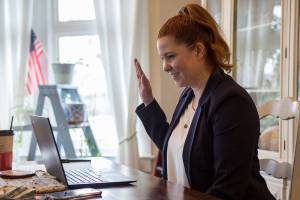 State Representative of the 38th Legislative District Emily Wicks raises hand during her virtual swearing in from her home on Friday, Jan. 8, 2020 in Everett, Wa. (Olivia Vanni / The Herald)