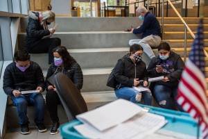 People sit outside of the County Public Meeting Room to fill out and turn in their ballots on Tuesday, Nov. 3, 2020 in Everett, Wa. (Olivia Vanni / The Herald)