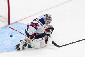 United States goalie Dustin Wolf (32) makes a save on Russia's Yegor Chinakhov (21) during the third period of an IIHF World Junior Hockey Championship game in Edmonton, Alberta, Friday, Dec. 25, 2020. (Jason Franson/The Canadian Press via AP)