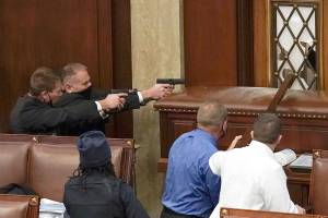 U.S. Capitol Police with guns drawn watch as protesters try to break into the House Chamber at the U.S. Capitol on Wednesday, Jan. 6, 2021, in Washington. (AP Photo/J. Scott Applewhite)