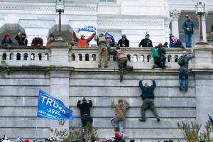 Supporters of President Donald Trump climb the west wall of the the U.S. Capitol on Wednesday, Jan. 6, 2021, in Washington. (AP Photo/Jose Luis Magana)