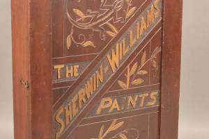 This wooden cabinet with decorations and the name Sherwin-Williams is easy to date. A salamander is carved on the door suggesting a date before 1905 when the logo was changed. We wonder why a paint company used a salamander and not a chameleon that changed colors. Did the artist draw the wrong creature? (Cowles Syndicate Inc.)