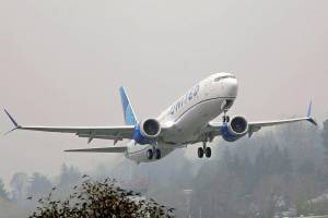 FILE - In this Wednesday, Dec. 11, 2019 file photo, a United Airlines Boeing 737 Max airplane takes off in the rain at Renton Municipal Airport in Renton, Wash. Boeing improperly influenced a test designed to see how quickly pilots could respond to malfunctions on the Boeing 737 Max, and Federal Aviation Administration officials may have obstructed a review of two deadly crashes involving the plane, Senate investigators say. In a report released Friday, Dec. 18, 2020 the Senate Commerce Committee also said the FAA continues to retaliate against whistleblowers.(AP Photo/Ted S. Warren, File)