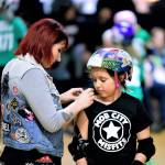 Coach Bombshell helps Mob City skater Evilyna with her jersey before a Mob City holiday scrimmage at the Everett Skate Deck on Dec. 9, 2018. An online fundraising effort has been started to help support the skating venue during the pandemic. (Anthony Floyd photo)