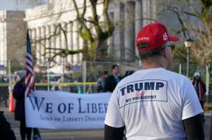 A supporter of President Donald Trump listens to speakers during a rally Sunday at the Capitol in Olympia, Wash. Protesters from several causes rallied Sunday at the Capitol, which was secured with a perimeter fence and National Guard members, the day before the 2021 legislative session was scheduled to begin. (AP Photo/Ted S. Warren)
