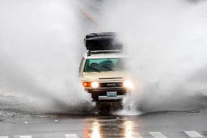 A car drives through a flooded street in Lynnwood, Wash., after a rainstorm Monday, Jan. 4, 2021.  (Mike Siegel/The Seattle Times via AP)