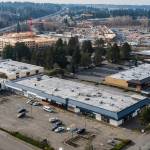 The Lynnwood strip-mall site (bottom) where Trent Development hopes to build 350 studio, one-bedroom and two-bedroom apartments. In the background is the Sound Transit Link light rail station that is under construction. (Olivia Vanni / The Herald)