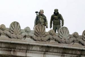 Law enforcement officers stand atop the Capitol in anticipation of protests Monday, Jan. 11, 2021, at the Capitol in Olympia, Wash. According to organizers, some protesters are unhappy the Legislature will be meeting virtually and in sessions not open to the public, due to the COVID-19 pandemic, during the 2021 session which opens Monday. Washington Gov. Jay Inslee activated members of the National Guard this week to work with the Washington State Patrol to protect the Capitol campus. (AP Photo/Ted S. Warren)
