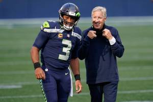 Seattle Seahawks quarterback Russell Wilson (3) talks with head coach Pete Carroll before an NFL football game against the New England Patriots, Sunday, Sept. 20, 2020, in Seattle. (AP Photo/Elaine Thompson)
