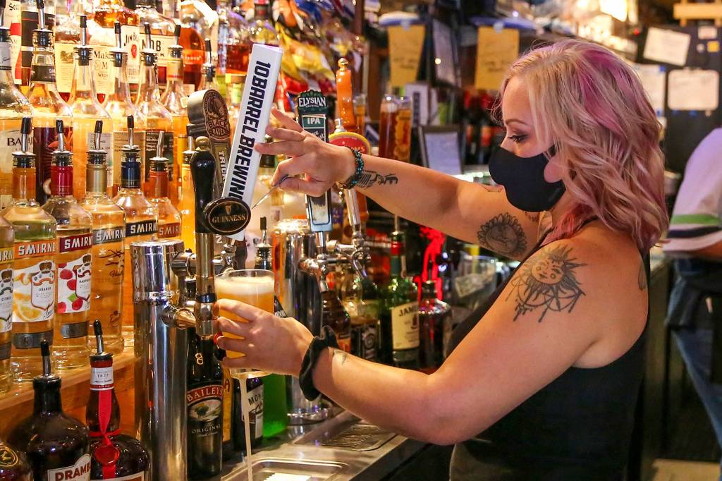 Carissa Hudson pulls a beer at Engels Pub in Edmonds. (Kevin Clark / The Herald)