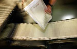 FILE - In this Feb. 26, 2009 file photo, a pressman pulls a copy of one of the final editions of the Rocky Mountain News off the press in the Washington Street Printing Plant of the Denver Newspaper Agency in Denver. A survey by Gallup and the Knight Foundation released on Sunday, Nov. 17, 2019, finds Democrats much more willing than Republicans to see government funding help local news sources. (AP Photo/David Zalubowski, File)