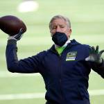 Seattle Seahawks head coach Pete Carroll tosses a football before an NFL wild-card playoff football game against the Los Angeles Rams, Saturday, Jan. 9, 2021, in Seattle. (AP Photo/Ted S. Warren)