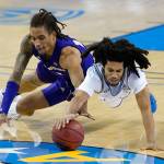 Washington forward Hameir Wright (left) and UCLA guard Tyger Campbell dive for a loose ball during the second half of a game Jan. 16, 2021, in Los Angeles. (AP Photo/Ashley Landis)