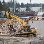 A view from a classroom in the new Stanwood High School shows crews tearing down parts of the old building, built in 1971, on Wednesday. (Andy Bronson / The Herald)