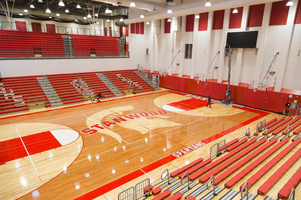 Crews work on the video display Wednesday in the main gym at Stanwood High School. (Andy Bronson / The Herald)