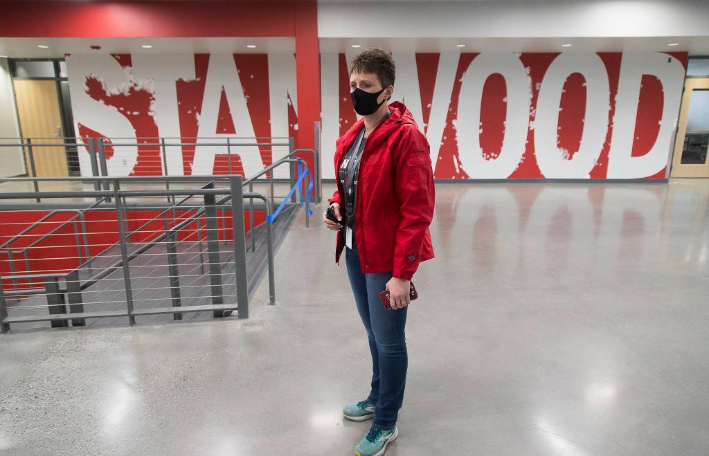 Stanwood High School Principal Christine Del Pozo stands in the main hallway Wednesday where a Stanwood sign awaits touch-up paint. (Andy Bronson / The Herald)