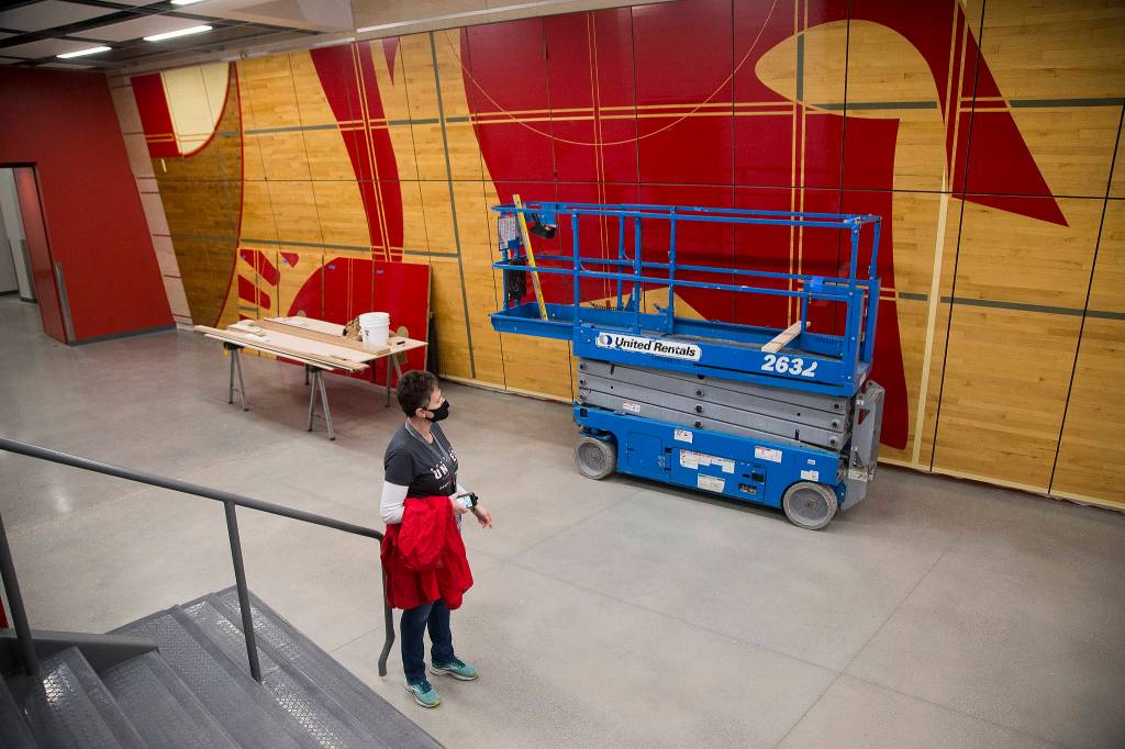 Principal Christine Del Pozo looks at a wall display made from the former schools gym floor in the new Stanwood High School. (Andy Bronson / The Herald)