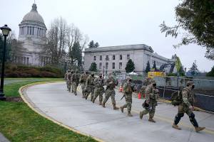 Washington National Guard members walk in formation away from the Legislative Building, Wednesday, Jan. 20, 2021, at the Capitol in Olympia, Wash. Members of the Guard and Washington State Patrol troopers have been in place all week on the campus providing security against possible protests connected with the inauguration of President Joe Biden and the departure of former President Donald Trump in Washington, D.C. (AP Photo/Ted S. Warren)