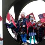 Children from the Childrens Workshop, an arts and science preschool, pause in a sculpture after walking their neighborhood with flags they made in celebration of the inaugurations of President Joe Biden and Vice President Kamala Harris, Wednesday, in Seattle. (Elaine Thompson / Associated Press)