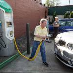 Brian Henderson of Renton plugs in his Kia Soul EV electric vehicle at a charging station in Sultan on in June of 2017. While electric vehicle owners pay a flat fee to the state for transportation needs, they dont pay a gas tax, which would increase under two proposals in the Legislature (Ian Terry / Herald file photo)