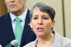 FILE - In this Jan. 24, 2019 file photo Washington Gov. Jay Inslee, left, looks on as Suzi LeVine, right, the state's Employment Security Department Commissioner, talks to reporters at the Capitol in Olympia, Wash. The state of Washington is calling in the National Guard to help process unemployment benefit claims as officials grapple with a backlog caused in part by a fraud ring that stole more than half a billion dollars in aid, officials said Thursday, June 11, 2020. LeVine said that Gov. Jay Inslee approved the deployment of troops who will start assisting her team next week as it tries to reduce the unemployment claim backlog.(AP Photo/Ted S. Warren,File)