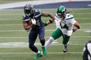 Seattle Seahawks wide receiver DK Metcalf (14) runs with the ball as New York Jets inside linebacker Harvey Langi gives chase during the first half of an NFL football game, Sunday, Dec. 13, 2020, in Seattle. (AP Photo/Ted S. Warren)