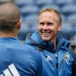 Seattle Sounders sporting director Chris Henderson greets a player after a soccer training session Monday, Feb. 22, 2016, in Seattle. The Sounders play Club America in the CONCACAF Champions League quarterfinal round on Tuesday. (AP Photo/Elaine Thompson)