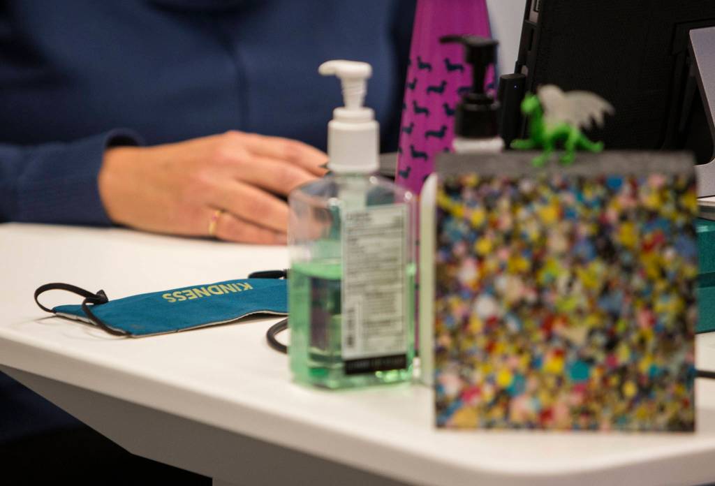A mask and hand sanitizer sit on Mayor Cassie Franklins desk Thursday during her State of Everett speech she gave remotely from her office in Everett. (Olivia Vanni / The Herald)