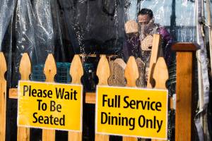 A waiter from Ivar's Seafood packages up food inside the outdoor dining tent on Wednesday, Dec. 9, 2020 in Mukilteo, Wa. (Olivia Vanni / The Herald)