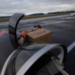 Ken Turpin struggles to fit a box of PPE into the front compartment of his RV-8 plane during an operation in which pilots delivered supplies to Native American tribes in Washington from Arlington Municipal Airport on Thursday. (Andy Bronson / The Herald)