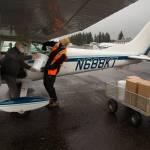 Before flying to Kelso, David Johnston (right) helps pilot Reilly Glore load his plane with PPE supplies at Arlington Municipal Airport on Thursday. (Andy Bronson / The Herald)