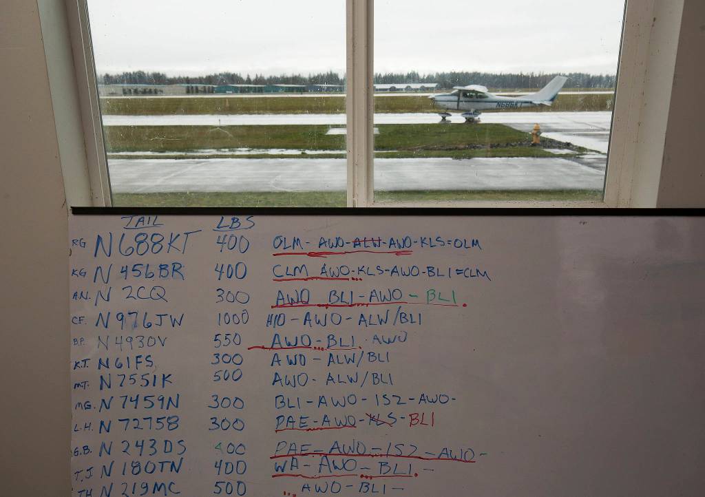 A whiteboard shows the routes that pilots are completing in an airlift of PPE supplies to tribes in Washington. (Andy Bronson / The Herald)
