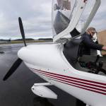 Pilot Greg Bell places a box into the passenger seat of his Diamond DA-40 plane as he prepares to airlift PPE supplies to Darrington from Arlington Municipal Airport on Thursday. (Andy Bronson / The Herald)