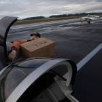 Ken Turpin struggles to fit a box of PPE into the front compartment of his RV-8 plane as another pilot taxies to the runway as pilots deliver supplies to Native American tribes in Washington from the Arlington Airport on Thursday, Jan. 28, 2021 in Arlington, Washington. More than 35,000 pounds of necessities were flown by volunteers to Native American tribes in all corners of Washington. It’s a unique partnership between a tribal support network and about 100 local pilots, delivering resources while also training for an even worse crisis. (Andy Bronson / The Herald)