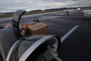 Ken Turpin struggles to fit a box of PPE into the front compartment of his RV-8 plane as another pilot taxies to the runway as pilots deliver supplies to Native American tribes in Washington from the Arlington Airport on Thursday, Jan. 28, 2021 in Arlington, Washington. More than 35,000 pounds of necessities were flown by volunteers to Native American tribes in all corners of Washington. It’s a unique partnership between a tribal support network and about 100 local pilots, delivering resources while also training for an even worse crisis. (Andy Bronson / The Herald)
