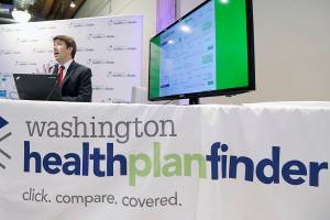 Brad Finnegan demonstrates the Washington Healthplanfinder website, where consumers will be able to shop for health insurance, following a news conference Monday, Sept. 30, 2013, in Seattle. The new site, which allows consumers to compare and purchase health insurance plans and to see if they are eligible for government subsidies, is Washington state's online answer to the Affordable Care Act, which is available to the public beginning Tuesday. (AP Photo/Elaine Thompson)