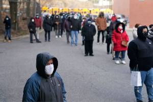 People wait in line for the COVID-19 vaccine in Paterson, N.J., Thursday, Jan. 21, 2021.  Some hospitals around the U.S. are facing complaints about favoritism and line-jumping after their board members and donors received COVID-19 vaccinations or offers for the prized inoculations.   (AP Photo/Seth Wenig)