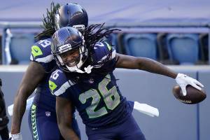 Seattle Seahawks cornerback Shaquill Griffin (26) is greeted by his twin brother, outside linebacker Shaquem Griffin (49) after Shaquill Griffin intercepted a pass against the Dallas Cowboys during the first half of an NFL football game, Sunday, Sept. 27, 2020, in Seattle. (AP Photo/Elaine Thompson)
