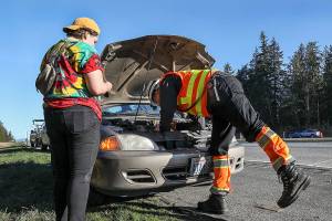 Buretta changes a faulty spark plug, getting a driver back on the road. (Lizz Giordano/ The Herald)