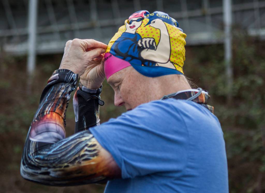 Kristin Galbreaith puts on a Rosie the Riveter swim cap before her swim. (Olivia Vanni / The Herald)