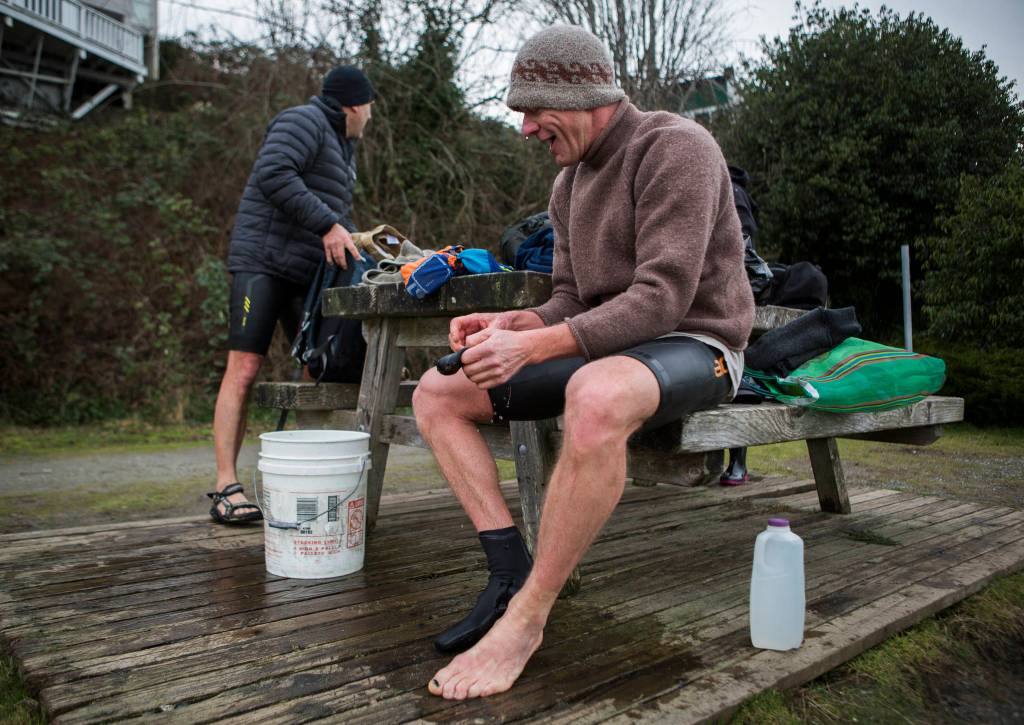 Brian McCleary (right) and Joe Hempel quickly bundle up to get warm Jan. 29 after completing their swim in Langley. (Olivia Vanni / The Herald)